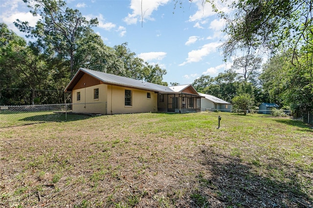 175 Cliff St, Deland, FL 32720 - back of property with a sunroom, metal roof, and view of scattered trees