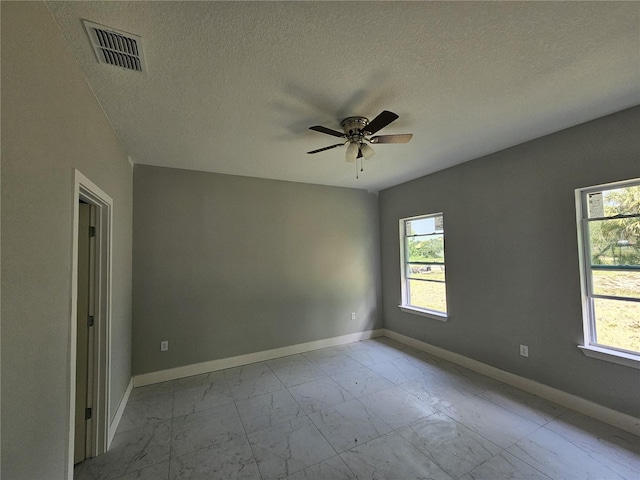 141 W G H Washington St, Apopka, FL 32703 - unfurnished room featuring marble finish floors, plenty of natural light, ceiling fan, baseboards, and a textured ceiling