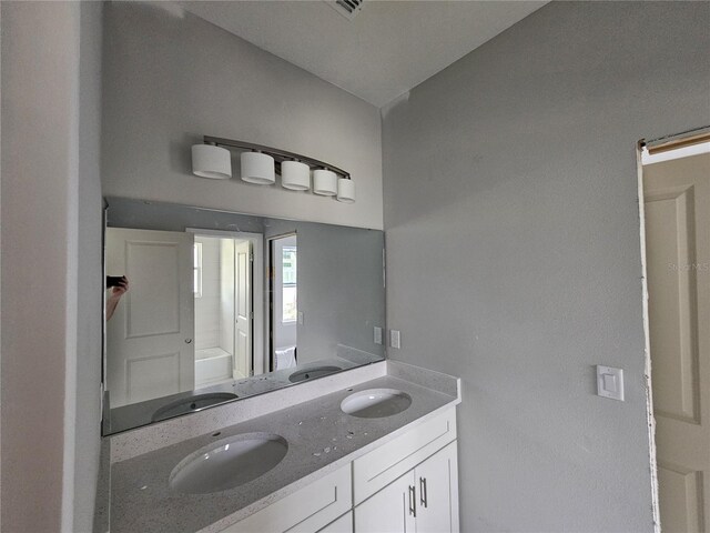 141 W G H Washington St, Apopka, FL 32703 - bathroom featuring double vanity and a tub to relax in