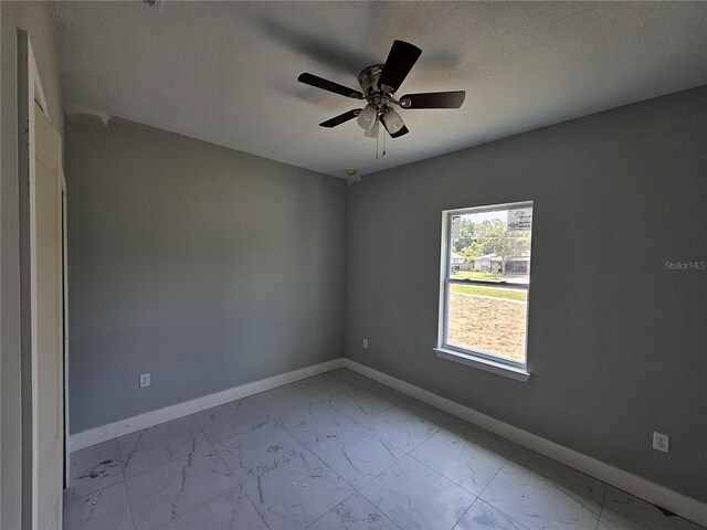 141 W G H Washington St, Apopka, FL 32703 - empty room featuring light marble finish floors, baseboards, ceiling fan, and a textured ceiling