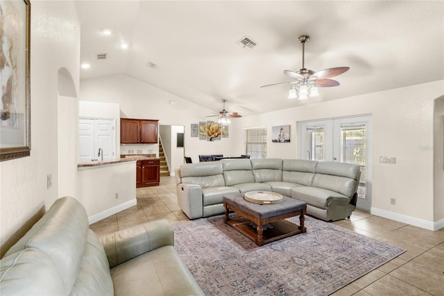 living room featuring vaulted ceiling, a ceiling fan, light tile patterned flooring, and baseboards