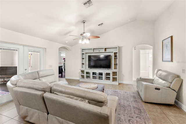 living room with arched walkways, ceiling fan, light tile patterned flooring, and lofted ceiling