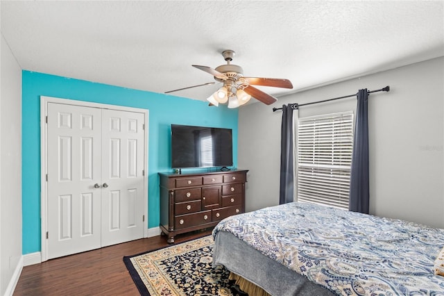 bedroom with wood finished floors, a closet, ceiling fan, and baseboards