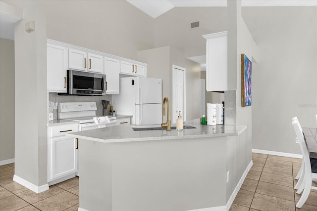 217 Holborn Loop, Davenport, FL 33897 - kitchen featuring white appliances, a sink, light tile patterned floors, white cabinets, and high vaulted ceiling