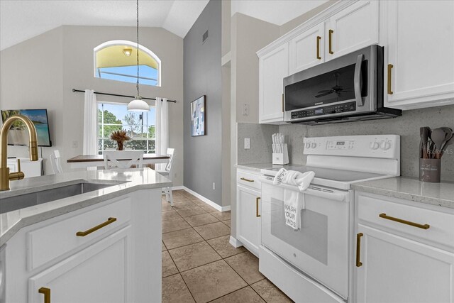 217 Holborn Loop, Davenport, FL 33897 - kitchen with stainless steel microwave, electric stove, a sink, white cabinetry, and light tile patterned floors