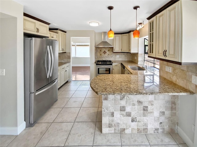 721 Rock Creek Loop, Longwood, FL 32750 - kitchen with appliances with stainless steel finishes, wall chimney range hood, cream cabinets, a sink, and a peninsula