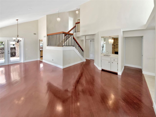 721 Rock Creek Loop, Longwood, FL 32750 - unfurnished living room with a chandelier, high vaulted ceiling, wood finished floors, stairway, and a sink