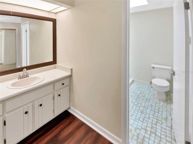 721 Rock Creek Loop, Longwood, FL 32750 - bathroom with toilet, baseboards, vanity, and wood finished floors