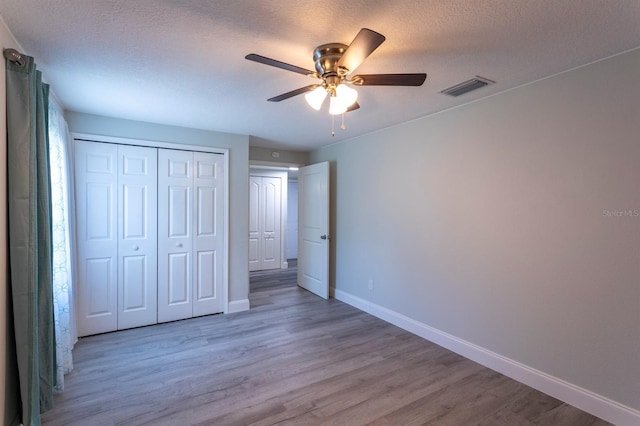 4515 Isaac Ln, Sanford, FL 32771 - unfurnished bedroom with baseboards, light wood finished floors, a closet, a textured ceiling, and ceiling fan