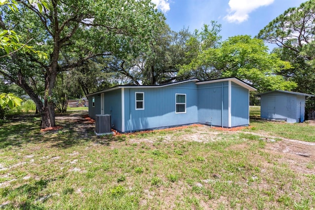 4515 Isaac Ln, Sanford, FL 32771 - rear view of house with central AC unit, a yard, and an outdoor structure