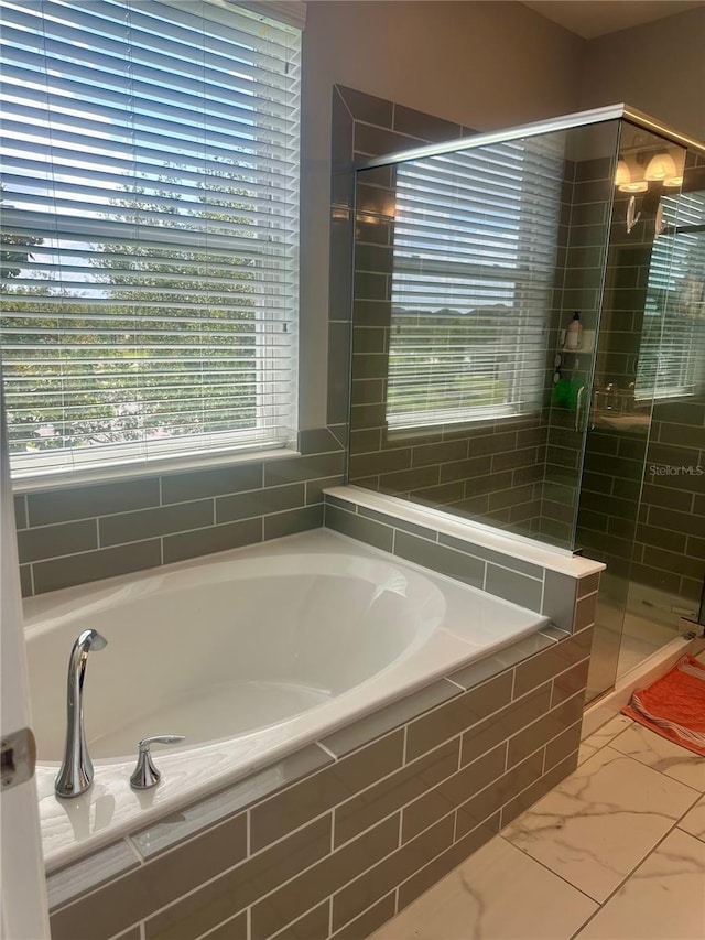 15708 Orange Harvest Loop, Winter Garden, FL 34787 - bathroom with a stall shower, a garden tub, and marble look tiles