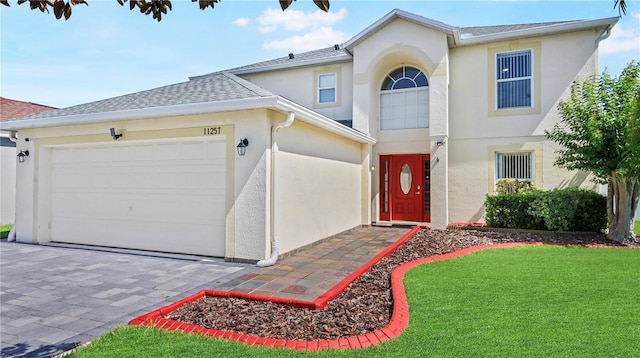 11257 Dacre Ln, Orlando, FL 32824 - traditional-style house with stucco siding, an attached garage, a front yard, and a shingled roof