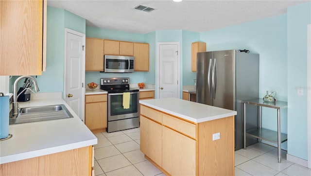 11257 Dacre Ln, Orlando, FL 32824 - kitchen with appliances with stainless steel finishes, a sink, light brown cabinetry, a kitchen island, and light tile patterned floors