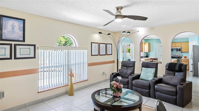 11257 Dacre Ln, Orlando, FL 32824 - living area featuring ceiling fan, a textured ceiling, arched walkways, and light tile patterned flooring