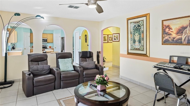 11257 Dacre Ln, Orlando, FL 32824 - living room with a ceiling fan, arched walkways, and light tile patterned flooring