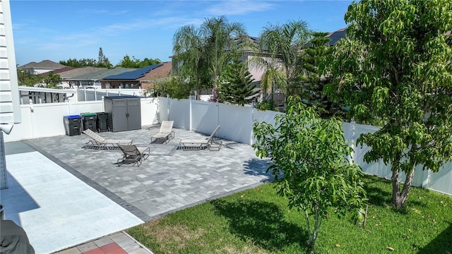 11257 Dacre Ln, Orlando, FL 32824 - view of patio / terrace with a storage unit, a fenced backyard, an outdoor structure, and a residential view
