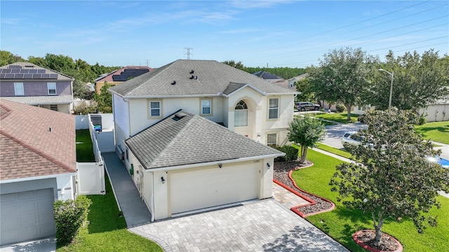11257 Dacre Ln, Orlando, FL 32824 - view of front of home with stucco siding, a shingled roof, driveway, and an attached garage