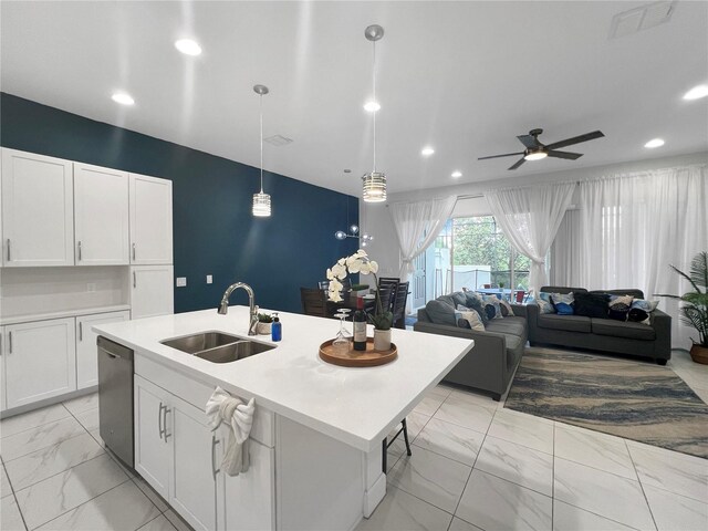 454 Captiva Dr, Davenport, FL 33896 - kitchen featuring a sink, light marble finish floors, stainless steel dishwasher, white cabinetry, and a center island with sink