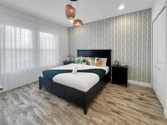 454 Captiva Dr, Davenport, FL 33896 - bedroom featuring wallpapered walls, an accent wall, wood finished floors, a closet, and recessed lighting