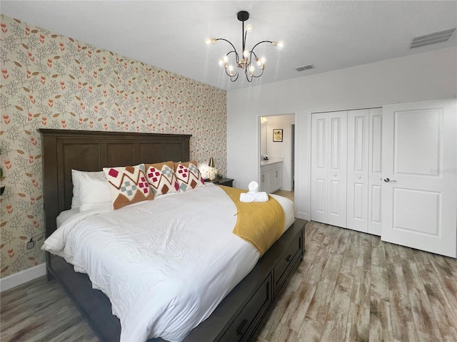 454 Captiva Dr, Davenport, FL 33896 - bedroom with light wood-style floors, a chandelier, a closet, baseboards, and wallpapered walls