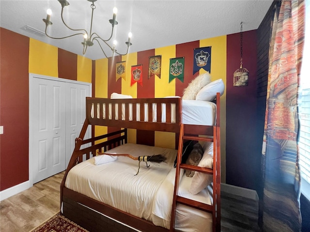 454 Captiva Dr, Davenport, FL 33896 - bedroom featuring wood finished floors, a chandelier, a closet, baseboards, and a textured ceiling