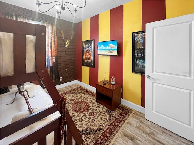 454 Captiva Dr, Davenport, FL 33896 - bedroom with a chandelier, baseboards, wood finished floors, and an accent wall