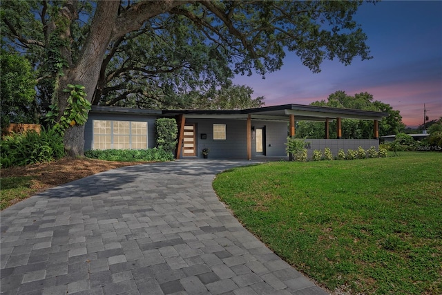 1401 Canberra Ave, Orlando, FL 32806 - mid-century home featuring a front yard, decorative driveway, and an attached carport