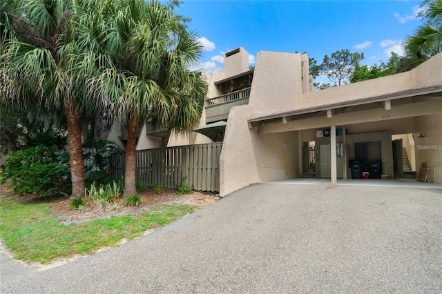 115 Tomoka Trl Unit 115, Longwood, FL 32779 - view of side of home with stucco siding, a carport, and asphalt driveway