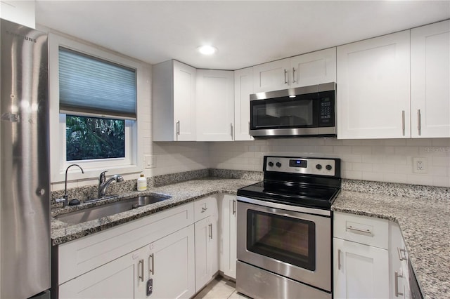 115 Tomoka Trl Unit 115, Longwood, FL 32779 - kitchen with appliances with stainless steel finishes, a sink, white cabinetry, decorative backsplash, and recessed lighting