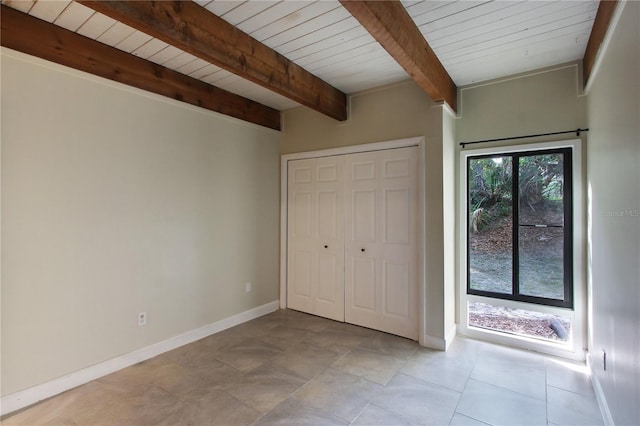 115 Tomoka Trl Unit 115, Longwood, FL 32779 - unfurnished bedroom featuring wooden ceiling with exposed beams, baseboards, a closet, and light tile patterned floors