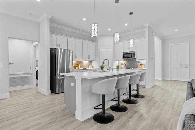 19073 Sabal St, Orlando, FL 32833 - kitchen with stainless steel appliances, a sink, light countertops, a breakfast bar, and a center island with sink