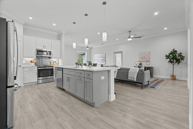 19073 Sabal St, Orlando, FL 32833 - kitchen with appliances with stainless steel finishes, ornamental molding, open floor plan, gray cabinets, and a sink