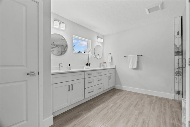 19073 Sabal St, Orlando, FL 32833 - full bath featuring a textured ceiling, double vanity, wood finished floors, a marble finish shower, and baseboards