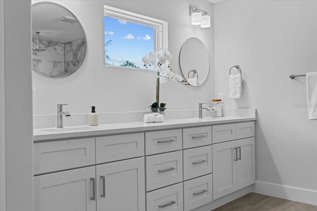 19073 Sabal St, Orlando, FL 32833 - bathroom featuring double vanity, a shower, wood finished floors, and baseboards