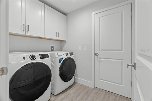 19073 Sabal St, Orlando, FL 32833 - laundry area featuring separate washer and dryer, cabinet space, light wood-type flooring, and baseboards