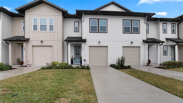 733 Longboat Dr, Davenport, FL 33896 - townhome / multi-family property featuring board and batten siding, driveway, an attached garage, and a front lawn