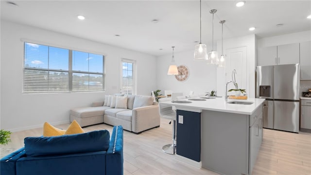 733 Longboat Dr, Davenport, FL 33896 - kitchen featuring stainless steel fridge, open floor plan, a sink, gray cabinetry, and light countertops