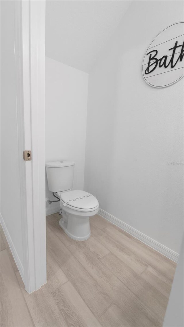 733 Longboat Dr, Davenport, FL 33896 - bathroom with wood finished floors, toilet, and baseboards