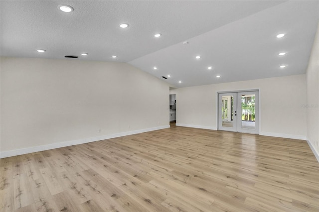 unfurnished living room with light wood finished floors, lofted ceiling, recessed lighting, french doors, and baseboards