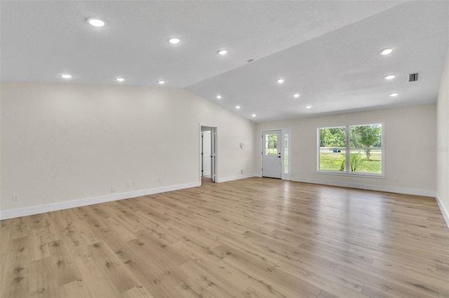 spare room with recessed lighting, light wood-type flooring, lofted ceiling, and baseboards