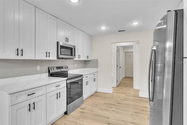 kitchen featuring appliances with stainless steel finishes, baseboards, white cabinetry, and recessed lighting