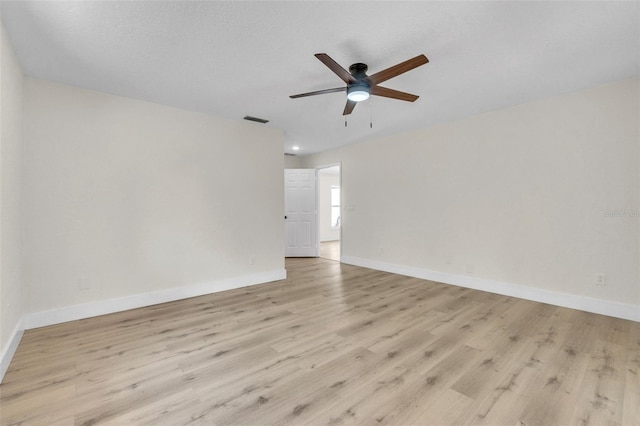 empty room featuring a ceiling fan, light wood-style flooring, and baseboards