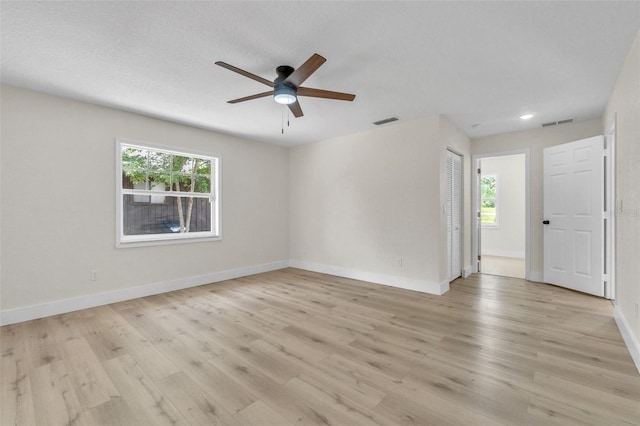 spare room with plenty of natural light, a ceiling fan, light wood-type flooring, baseboards, and recessed lighting