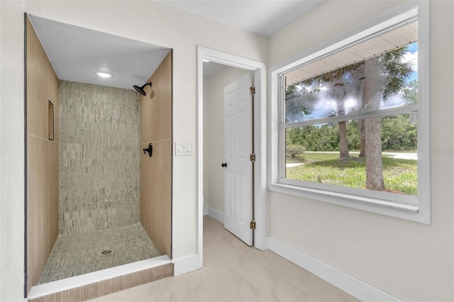 bathroom featuring a shower stall, marble finish flooring, and baseboards