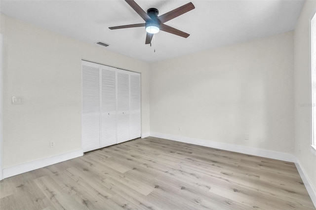 unfurnished bedroom with a closet, wood finished floors, baseboards, and ceiling fan