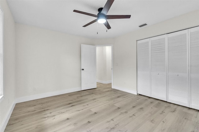 unfurnished bedroom with light wood-style floors, baseboards, a closet, and a ceiling fan