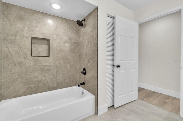 bathroom with shower / bath combination and baseboards
