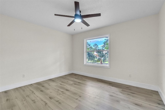 spare room with baseboards, wood finished floors, and ceiling fan