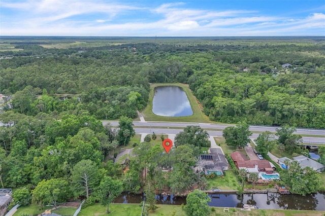 aerial view of property and surrounding area featuring a forest and a large body of water