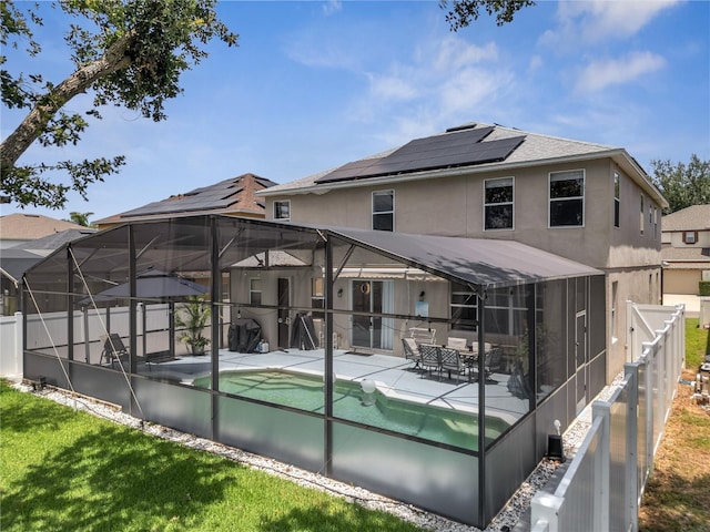 325 Aldridge Ln, Davenport, FL 33897 - rear view of house with a patio, stucco siding, a shingled roof, a fenced backyard, and a lanai